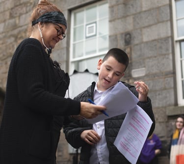 Production manager at a production company with a woman and a boy in front of a building