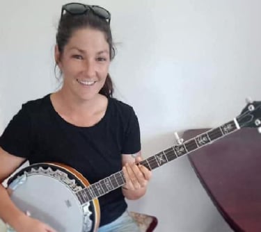 a woman holding a banjoette and smiling