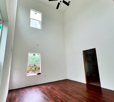 Primary bedroom with 20-foot ceilings and oversized windows in Texas custom home