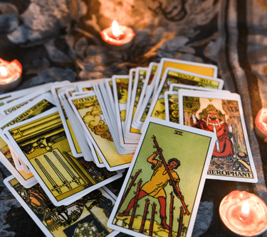 a bunch of tarot cards with candles and candles