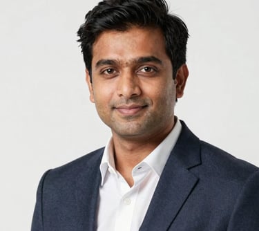Professional studio portrait of a South Asian male in a business casual outfit, appearing friendly and approachable, clean white background.