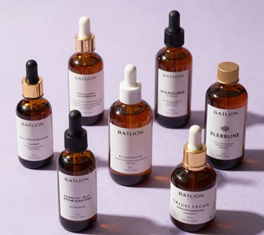 Photography of high-end skincare bottles arranged artistically on a light lilac textured surface. South American / Brazilian brand aesthetic.