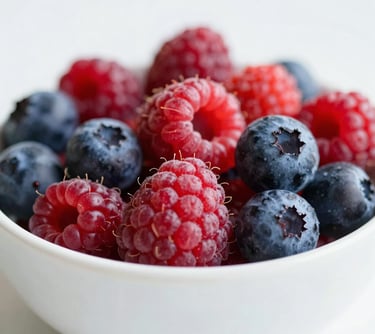 Close-up of colorful, fresh berries in a white ceramic bowl, representing conscious nutrition and attention to detail, soft and airy aesthetic.