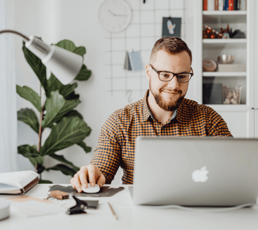 a man sitting at a desk with a laptop computer