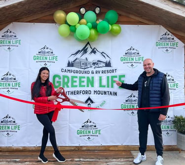 A couple celebrates the grand opening of Green Life Campground & RV Resort with a ribbon cutting ceremony.