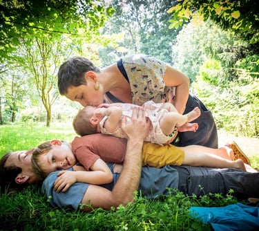 Photo portrait en couleur d'une famille dans un jardin ensoleillé