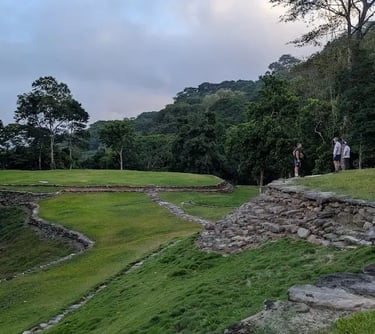 Tourists exploring the stone terraces and circular ruins of Ciudad Perdida in the Colombian jungle.