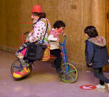 clown avec un chapeau rouge et un vélo d'enfant