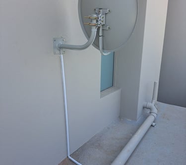 A beautiful dstv dish installed with the cables covered in a conduit pipe