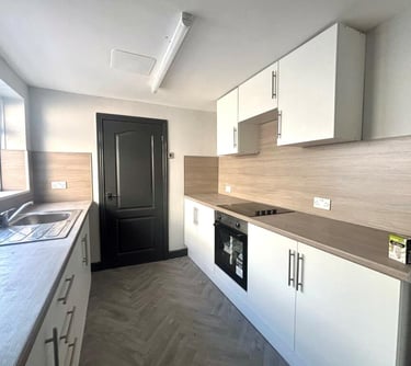 a kitchen with a stove top oven and a sink