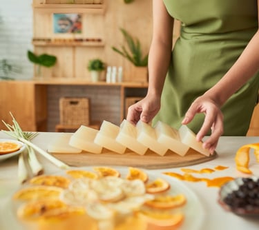 a woman is cutting up some cheese on a cutting board
