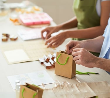 a man and woman are making a paper bag