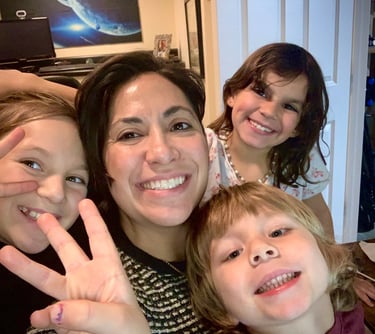 a woman with two children and a baby in a living room