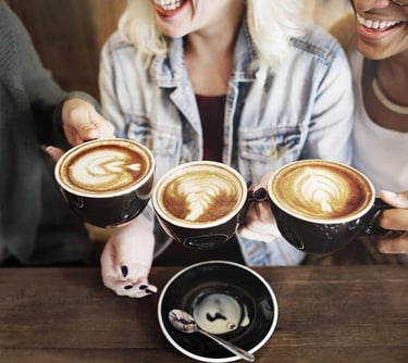 a group of people sitting at a table with coffee cups