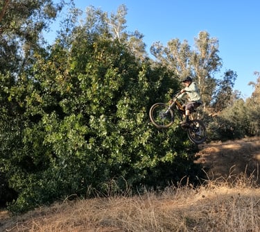 mountain biker performing rear brake tap mid air technique