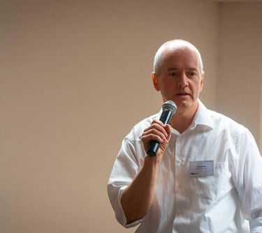 Jörg Grube hält beim Vortragen ein Mikorophon in der Hand
