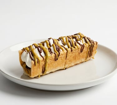 Le Menifeuille du Chef Menisy : feuilleté croustillant garni de crème, nappage chocolat et pistache, création signature.