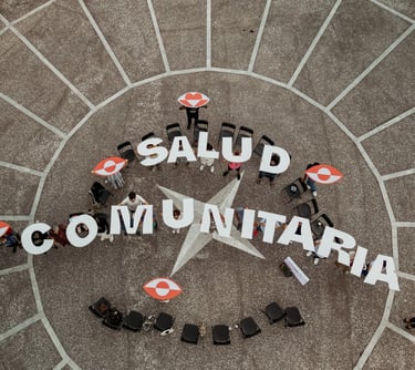 un grupo de personas de pie sujetando letras que conforman las palabras salud comunitaria