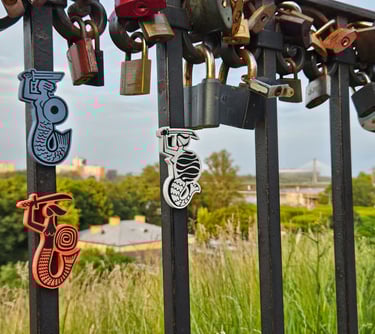Trzy magnesy z Syrenkami Warszawskimi na tle mostu Świętokrzyskiemu