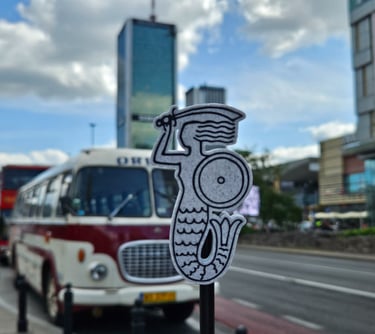 Magnes z Syrenką Warszawską na tle retro Busa w Warszawie