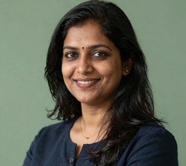 Professional headshot of an Indian female placement expert, friendly and professional, with a sage green background.