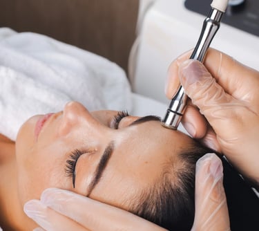 A woman receiving a professional diamond microdermabrasion facial treatment to exfoliate and rejuvenate skin.