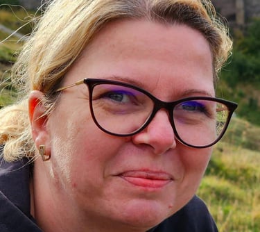 a woman with glasses and a black jacket