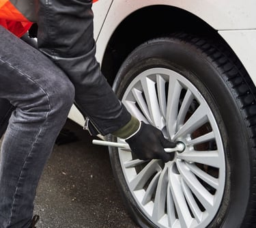 a person standing on a tire with a wrenet