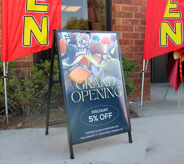 a sign board with a grand opening sign