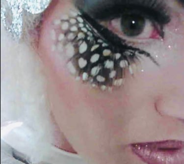 geschminktes Frauengesicht mit Ferderwimpern,Glitzerlippen und Rouge