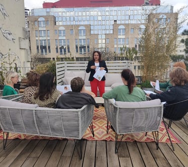 Groupe d’élèves assis sur une terrasse, suivant une formation dirigée par une formatrice.