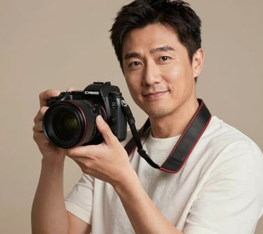 A professional portrait of a photography expert holding a high-end camera, looking directly at the viewer with a friendly and confident expression. Set against a warm, neutral background in a North American / European studio.