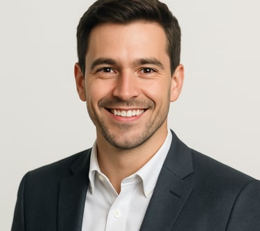 A professional headshot of a smiling male professional in a modern blazer, looking directly at the camera with confidence. Bright, clean studio lighting with an off white background. North American / International style.