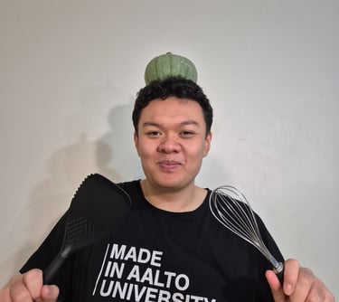 a man with a pumpkin on his head and a whisk and spatula in each of his hands