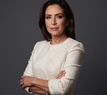 A professional portrait of a Latin American woman in her 40s, looking confident as a lead producer, dressed in professional pearl-colored clothing against a clean dark slate grey background.