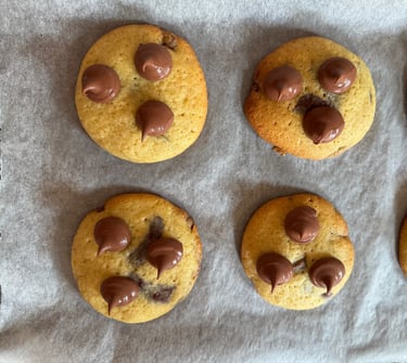 a bunch of chocolate chip cookies on a baking sheet