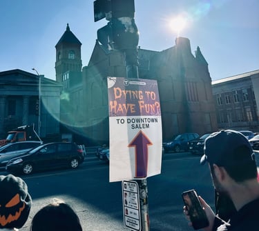 a sign that says "Dying to have fun? To downtown Salem"
