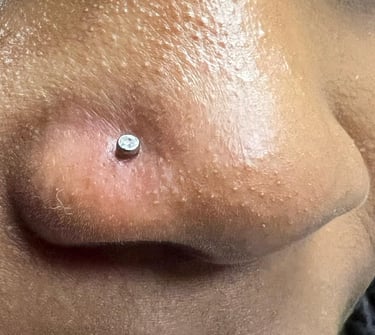 a close up of a nose piercing on a woman's nose