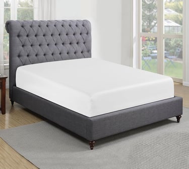 a bed with a gray bed and a chair