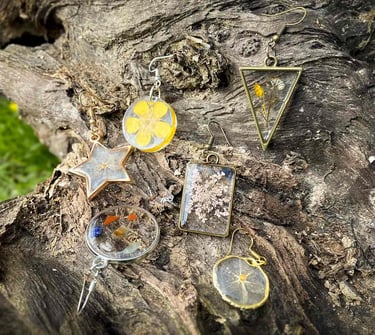 boucles-d'oreilles colorées et uniques posées sur une souche d'arbre