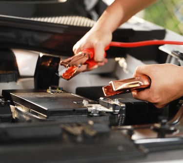 a person is holding battery jumper cables in both hands