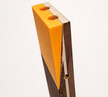A textured orange door wedge mounted on a vertical dark wood board with holes.