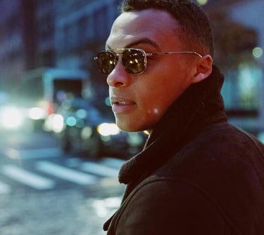 Man walking at night in the street, wearing stylish eyewear
