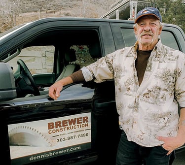 Dennis Brewer, master carpenter and owner of Brewer Construction, standing by his company truck in Golden, Colorado.