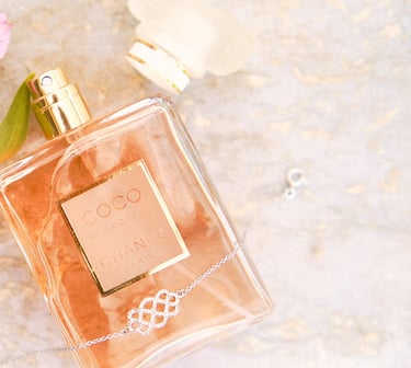 a bottle of perfume next to a flower