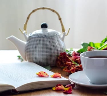a teapot and tea cup with detox herbal tea and a book to journal your retreat