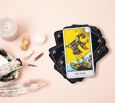 The Fool tarot card on a stack with crystals used in beginner tarot learning.