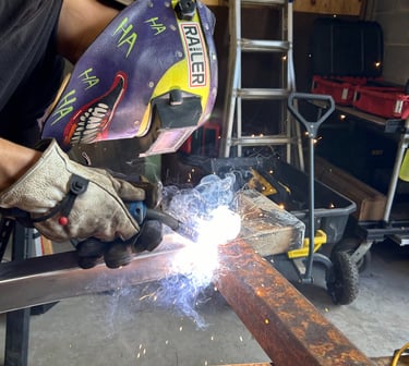 a man welding a beam of steel