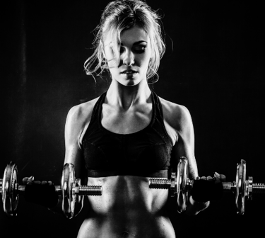a woman in a sports bra top and a pair of dumbs