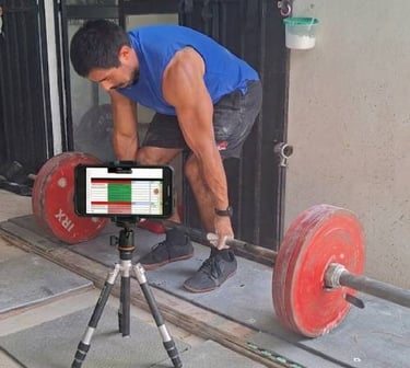 Una persona haciendo peso muerto mientras tiene su entrenamiento en el teléfono